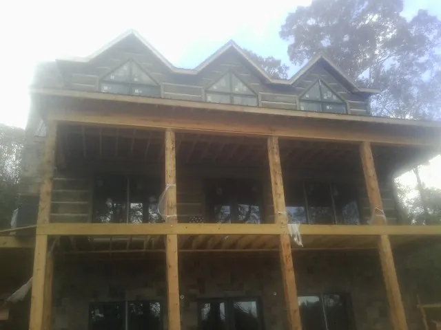 Dormers and porch framing on a large log home under construction — Roof Coating work by our crew in Cathlamet