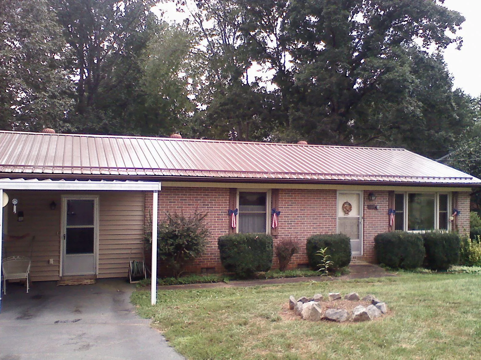 Bronze metal roof and carport on a brick ranch home — Roof Repair work by our crew in Cathlamet